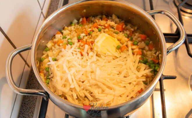 Roer boter en parmezaan door de risotto en serveer