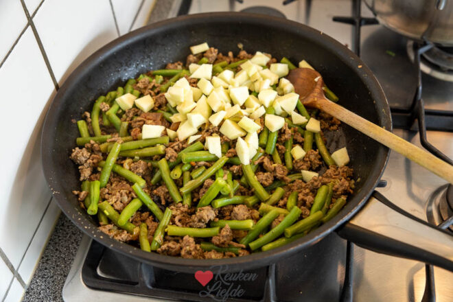 Roer de appel en sperziebonen door gehakt