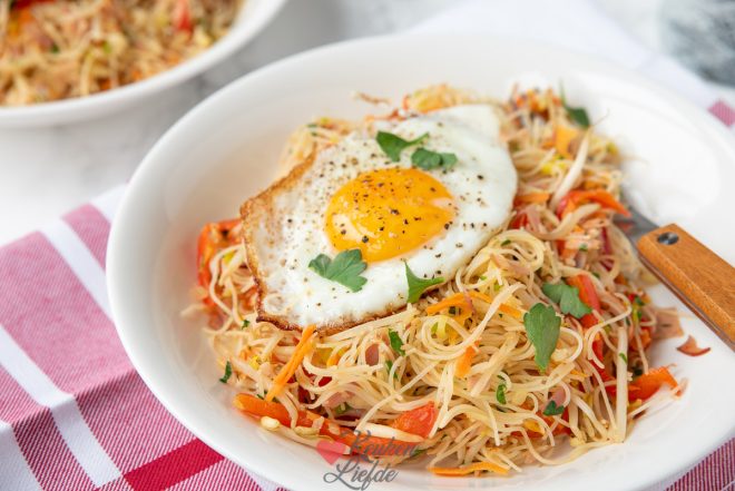 Serveer de mihoen goreng met gebakken ei