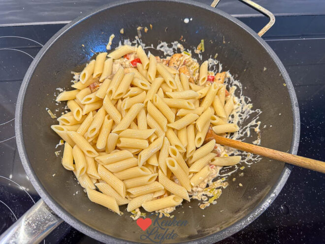 Roer de pasta en kip door de saus
