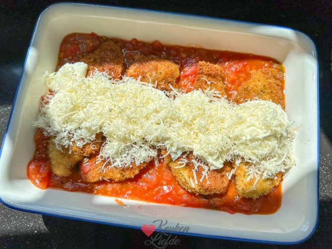 Verdeel de tomatensaus en kipschnitzels over een ovenschaal