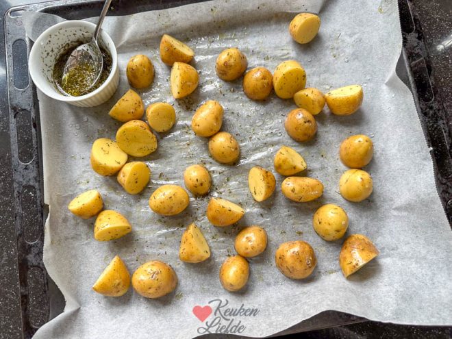 Schep de krieltjes om met kruidenolie en bak 10 minuten in de oven